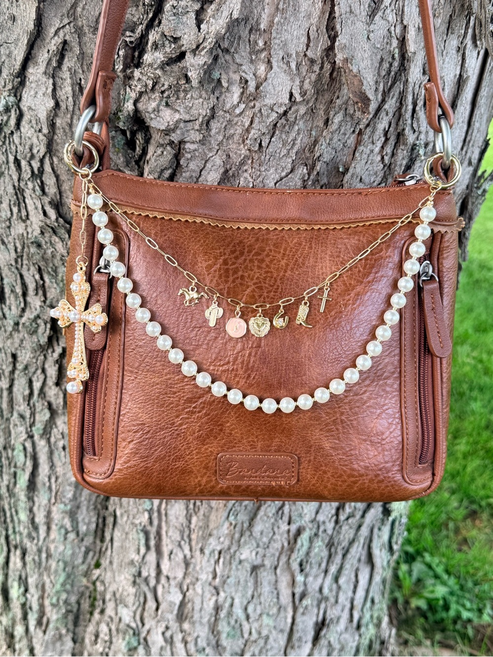 Pearl & Gold tone chain with charms and a large cross charm. Purse not included